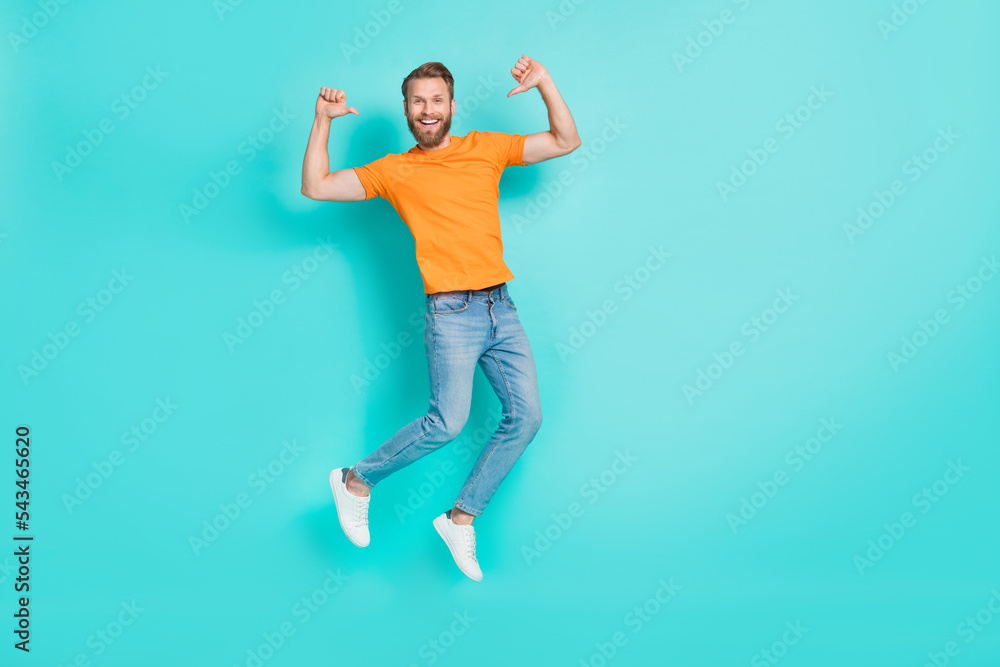 Full size photo of optimistic satisfied man muscular beard wear orange t-shirt jeans flying directing at himself isolated on teal color background