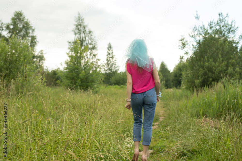 Girl stands on path in park. Nature walk. Bridesmaid went into woods. Girl stands on path in park. Nature walk. Bridesmaid went into woods.