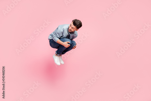 Full body photo of nice young man active sporty jumping bomb have fun screaming wear stylish blue clothes isolated on pink color background