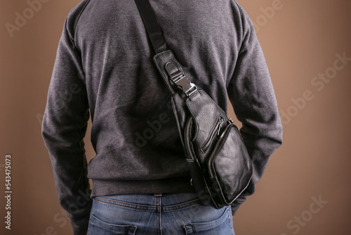 men leather sling bag is on person close up photo