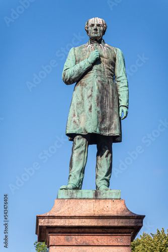 Helsinki, Finland - July 19, 2022: Closeup of Johan Ludvig Runeberg bronze statue on pedesta in Esplanadi park against blue sky. photo