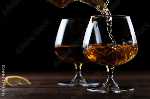 Cognac is poured into a glass from a bottle.