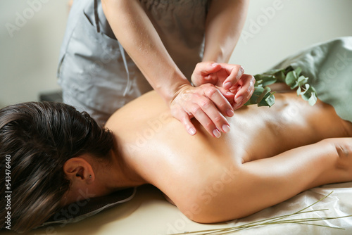 back massage and aromatherapy close up. masseurs hands are doing back massage to woman photo