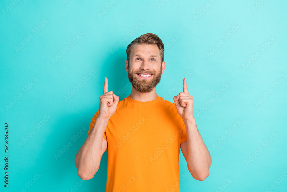 Photo of cheerful optimistic man with blond hairstyle dressed orange t-shirt directing look empty space isolated on teal color background Photo of cheerful optimistic man with blond hairstyle dressed orange t-shirt directing look empty space isolated on teal color background