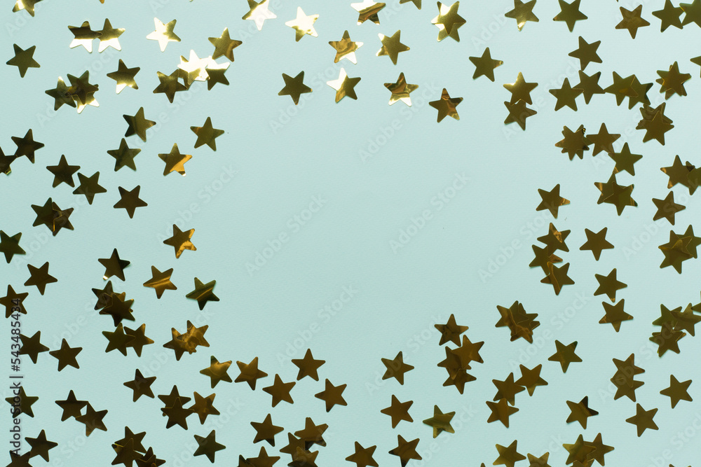 Golden confetti stars on color background, top view Golden confetti stars on color background, top view