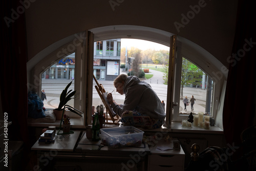 Mädchen malt vor offenen Fenster