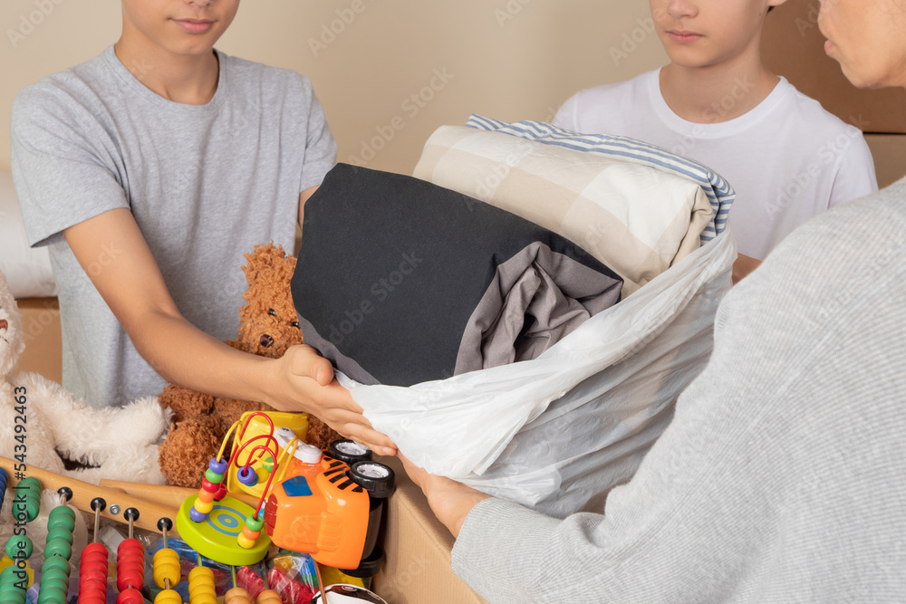 Young volunteers collect donations for charity indoors. Donation boxes
