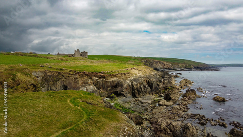 Overcast cloudy sky over the rocky coast of Ireland. Beautiful nature of northern Europe. Green fields on the coast. Drone point of view.
