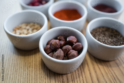 set of spices on wooden background, pomegranate, pine nut, hazelnut
