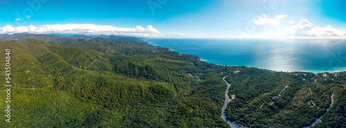 aerial panorama view of the Black Sea coast of the forested mountains of the Caucasus near the resort village of Magri on a sunny summer day
