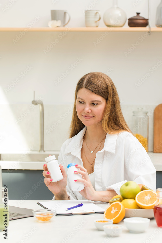 A nutritionist advises a client at an online appointment on a schedule for taking vitamins and dietary supplements.