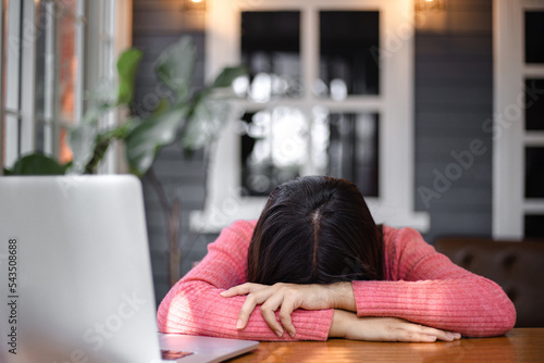 Fotografie A discouraged girl leans on the table