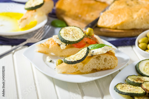 focaccia with tomatoes, cheese, olive oil and other additions