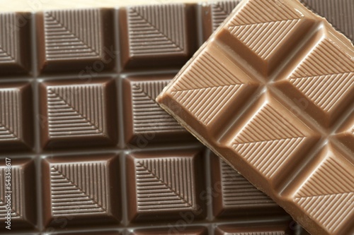 High angle cropped view of milk and dark chocolate squares with little diagonal lines on  them