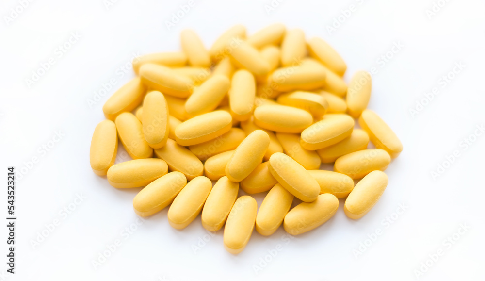 Close-up texture of yellow multivitamin tablets on white background. Healthy lifestyle concept Close-up texture of yellow multivitamin tablets on white background. Healthy lifestyle concept