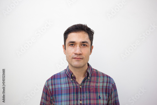 Photograph of adult man on white background for ID. Photo for documents. Mugshot picture of brunet male person wearing checkered shirt. Passport portrait. Soft focus. Film grain texture.