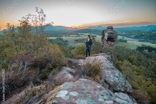  Eine Frau genie  t nach der Wanderung  vom Gipfel des Berges  die atemberaubende Aussicht der Landschaft mit einem wundersch  nen Sonnenuntergang im Pf  lzer Wald