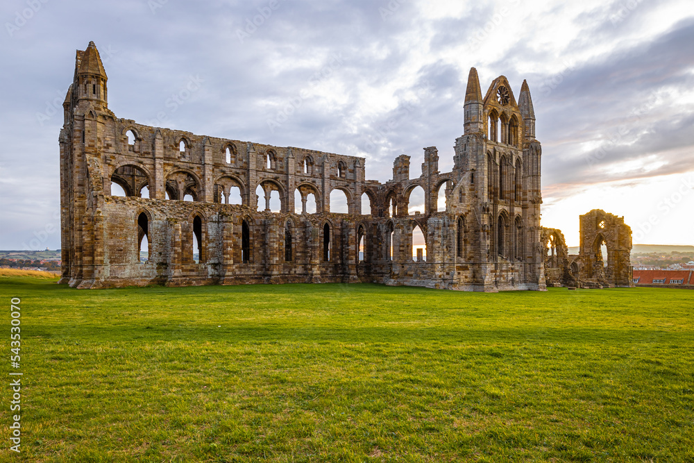 Fototapeta premium Sunset view of Whitby abbey overlooking the North Sea on the East Cliff above Whitby in North Yorkshire, England