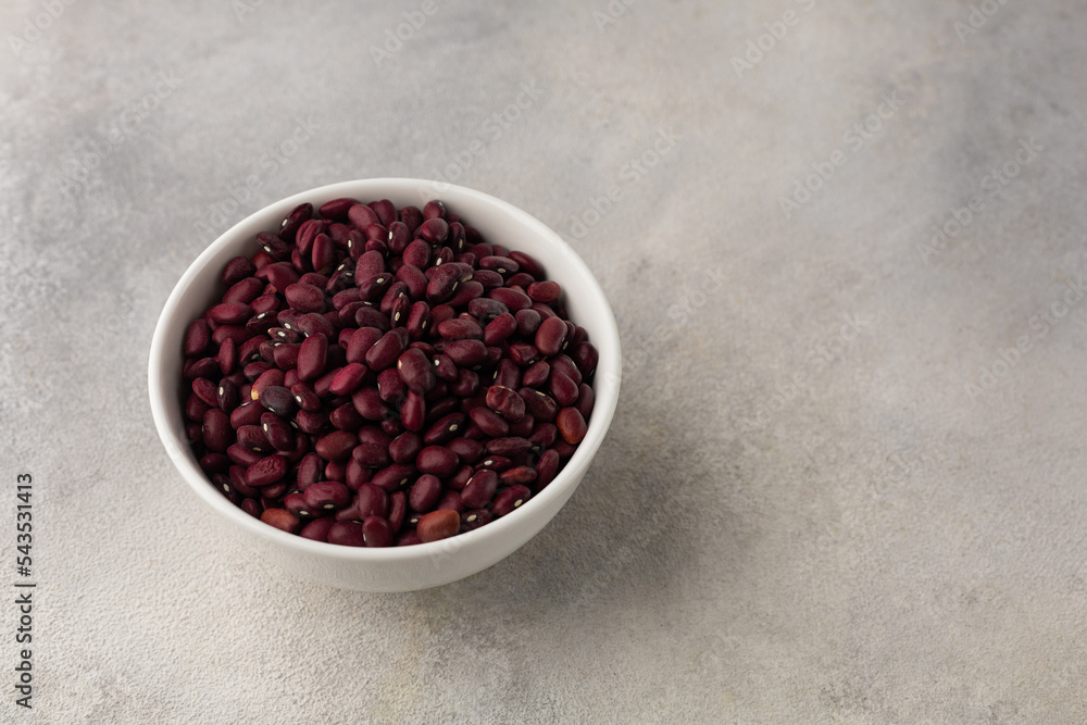 White bowl with red dry beans on a light background White bowl with red dry beans on a light background