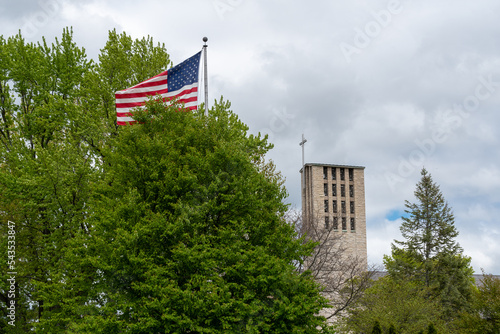 An American Flag And A Church Steeple And Cross