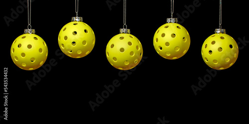 Pickleball Christmas.  5 Yellow Pickleball ornaments in a line on the upper part of a black background.