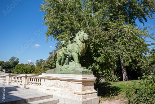 Dia soleado de otoño en el parque del Retiro del Madrid con las hojas aun verdes y sus famosos leones