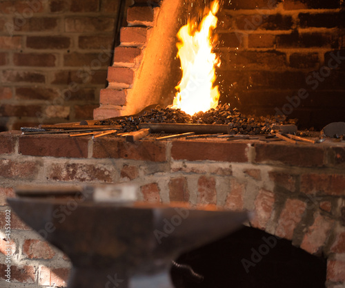 Fire for forging in a brick fireplace with coal and tools