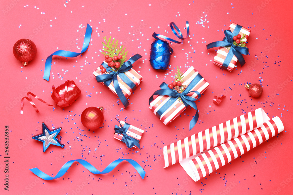 Wallpaper greeting card Merry Christmas holiday composition with blue white striped gift box present toy ball decoration on red background. Xmas New Year winter design idea concept. Top view, Flat lay