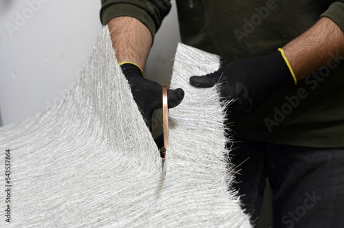 Fotografija Fiberglass sheets in various sizes are cut with scissors for the creation of ind