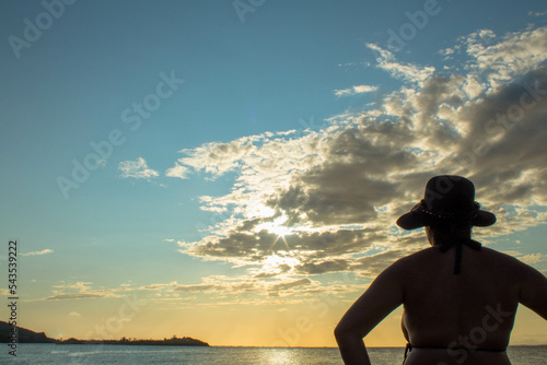 silhouette of woman looking at sunset on the beach