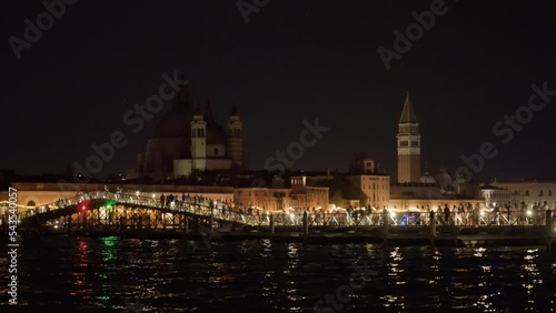 People walk on long pontoon bridge on Feast of Redeemer in Venice in late evening. Celebration of historical event in Italian city photo