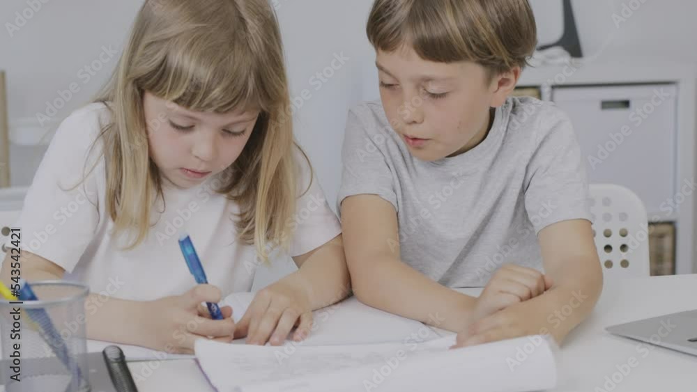 Brother helps his younger sister to make her homework. Brother helps his younger sister to make her homework.