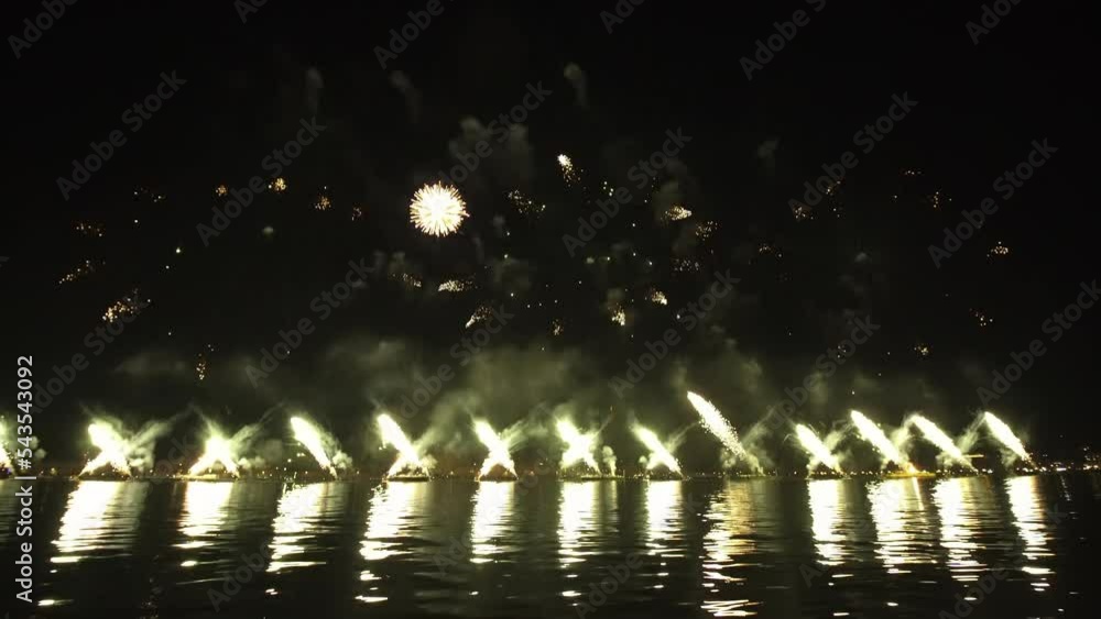 Bright fireworks launched in turn over city reflecting on water surface at night in Venice. Traditional show at end of Feast of Redeemer celebration Bright fireworks launched in turn over city reflecting on water surface at night in Venice. Traditional show at end of Feast of Redeemer celebration