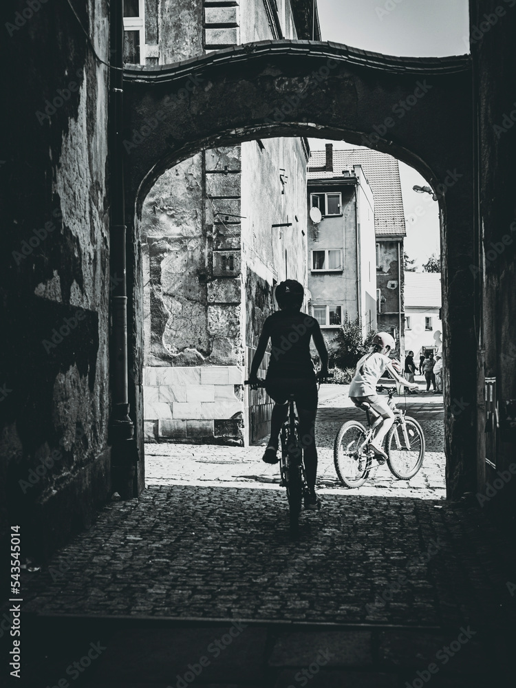 family on bicycles in the street alley