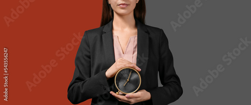 Businesswoman holding alarm...