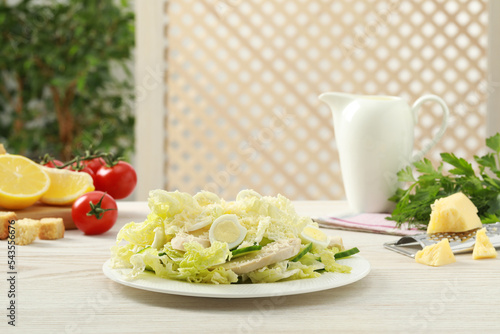 Delicious salad with Chinese cabbage, eggs and meat served on white wooden table