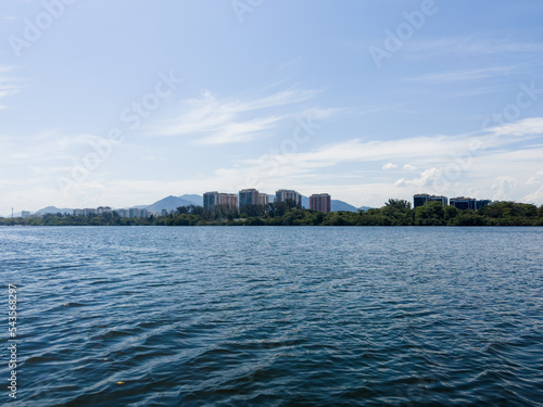 View of the Marapendi lagoon with buildings in the background and surrounding vegetation and trees. Hills in the background. Located near Praia da Reserva in Rio de Janeiro photo