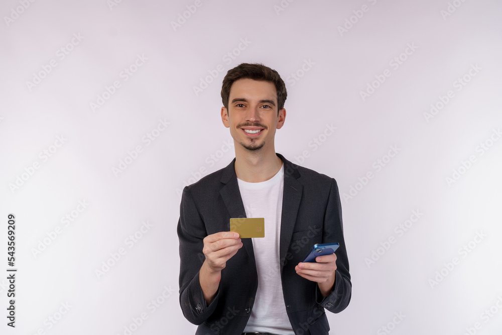 Portrait of happy young businessman standing using mobile cell phone and holding credit bank card isolated on white color background studio Portrait of happy young businessman standing using mobile cell phone and holding credit bank card isolated on white color background studio