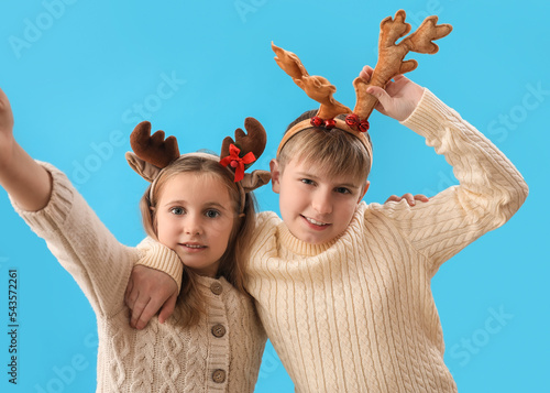 Little children in reindeer horns on blue background