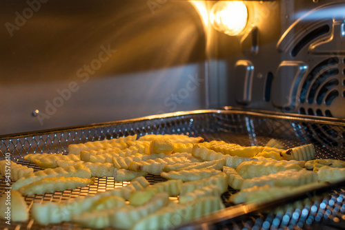 french fries cooking inside an air fryer style oven