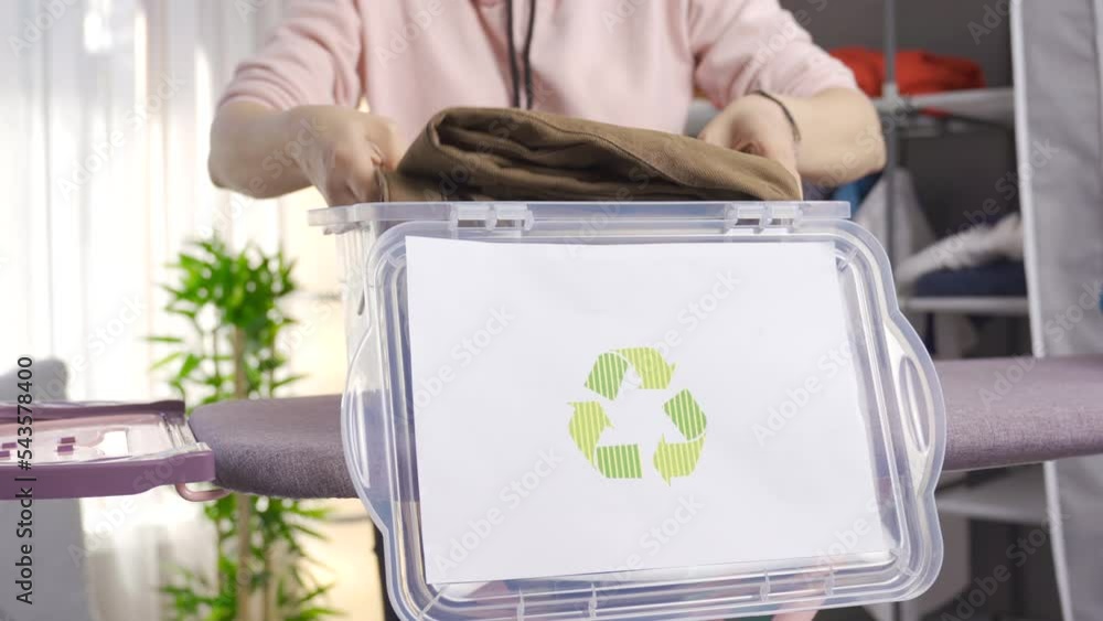 Recycle bin. Recycling at home. Ecofriendly woman throws clothes in