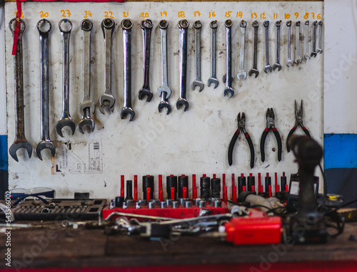 Spanners and tools on mechanics workbench in car garage