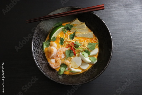 Singapore Laksa Instant Noodle Soup With Shrimp, Fish Balls, Fried Tofu, Cilantro, Thai Chili, Lime, Top Down View