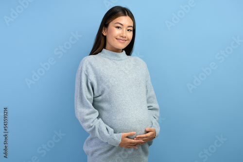 Image of a beautiful young pregnant asian woman posing isolated