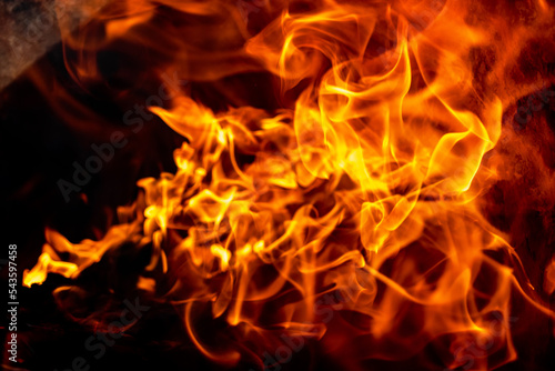 Burning fire close up. Bright orange and red flames on a dark background. Open flame heating. Problems with heating and gas. © Anoo