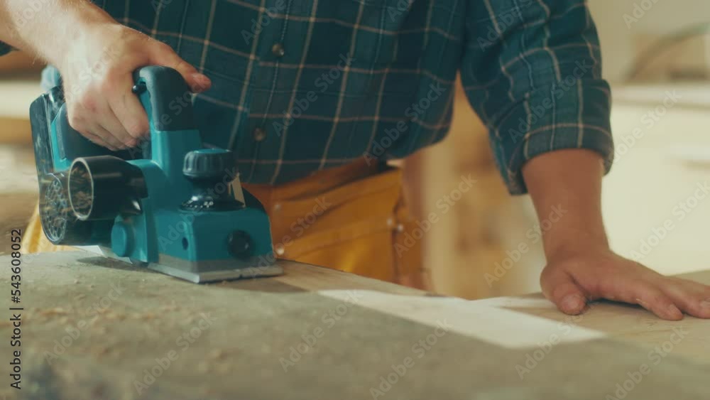 Close-up of Hands Polishing Wood With a Machine Planer. Woodworking. Manual Labor. Craftsmanship, and Handwork Concept. Grinds the Surface of Natural Wood Close-up of Hands Polishing Wood With a Machine Planer. Woodworking. Manual Labor. Craftsmanship, and Handwork Concept. Grinds the Surface of Natural Wood