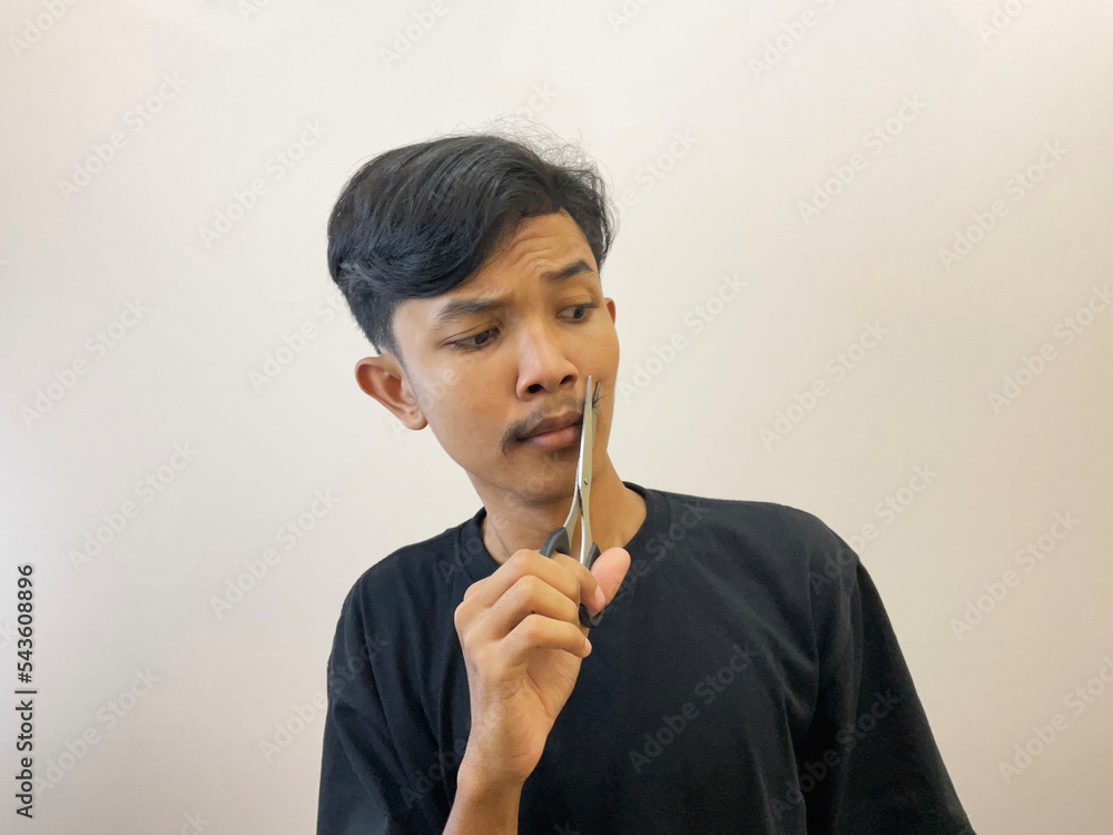 man cutting his own beard using scissors by himself man cutting his own beard using scissors by himself