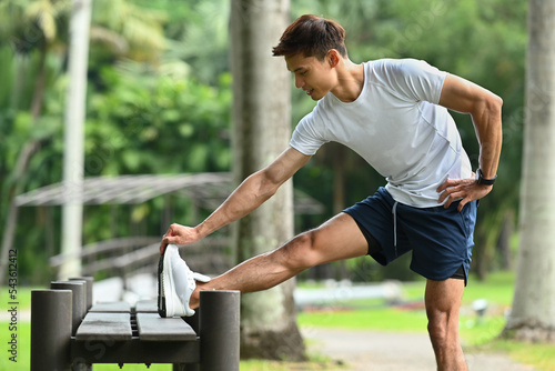 Handsome asian man in sportswear stretching legs, warming up before morning workout at outdoors. Healthy lifestyle concept © Prathankarnpap