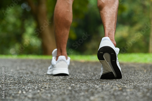 Close up view of strong athletic legs of sport man jogging running on the road. Fitness, sport and healthy lifestyle concept