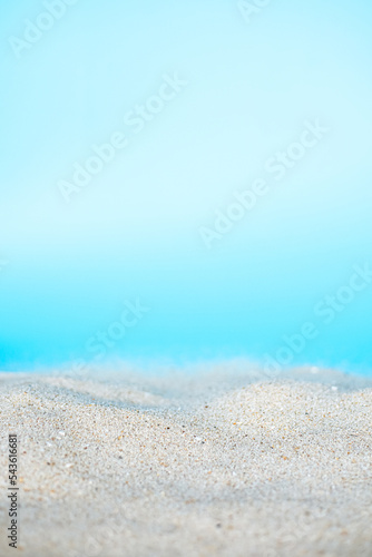 Sea beach sand texture on blue background with selective focus. Summer background. 